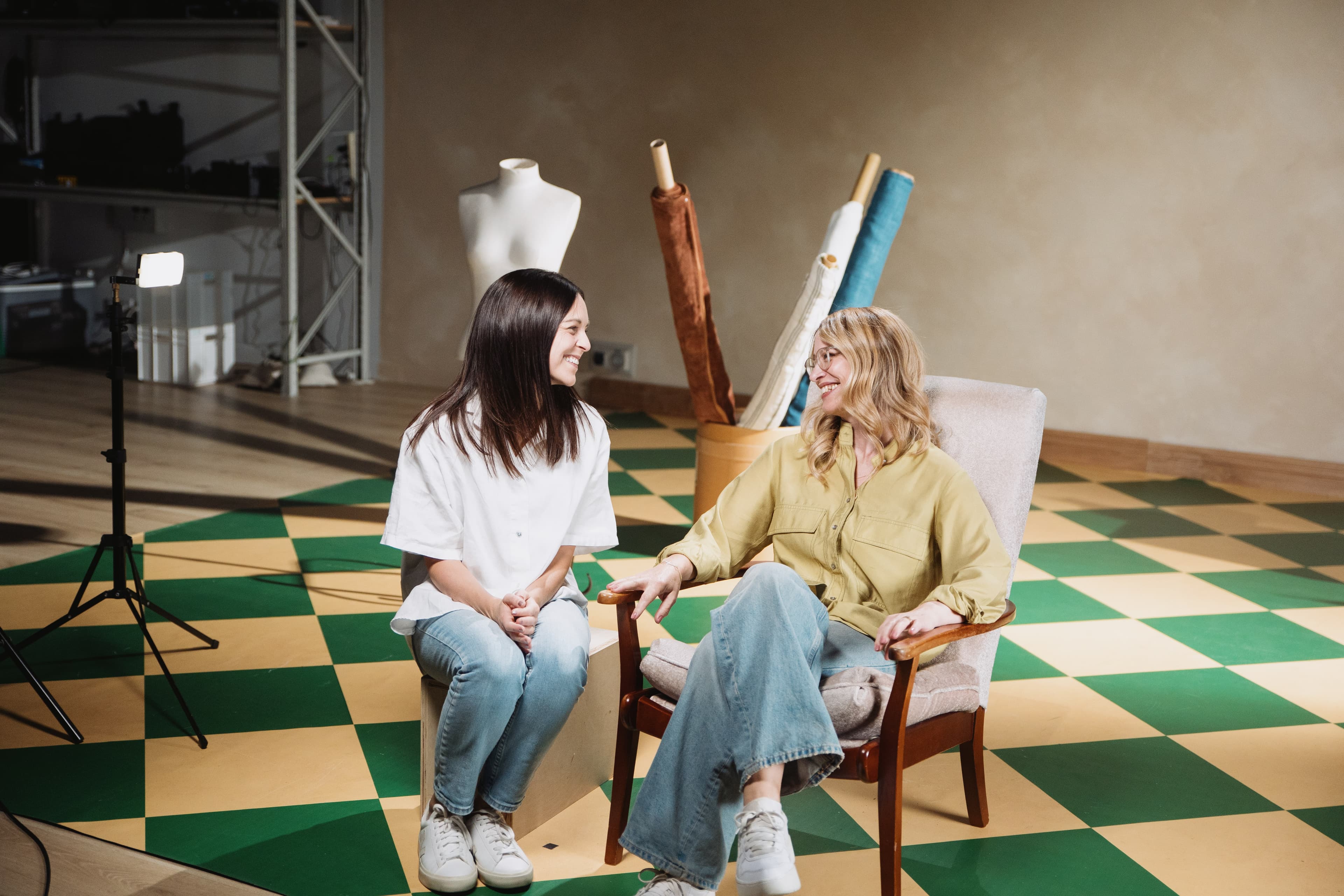 Two women on the set of the KNOWN film series looking at each other smiling