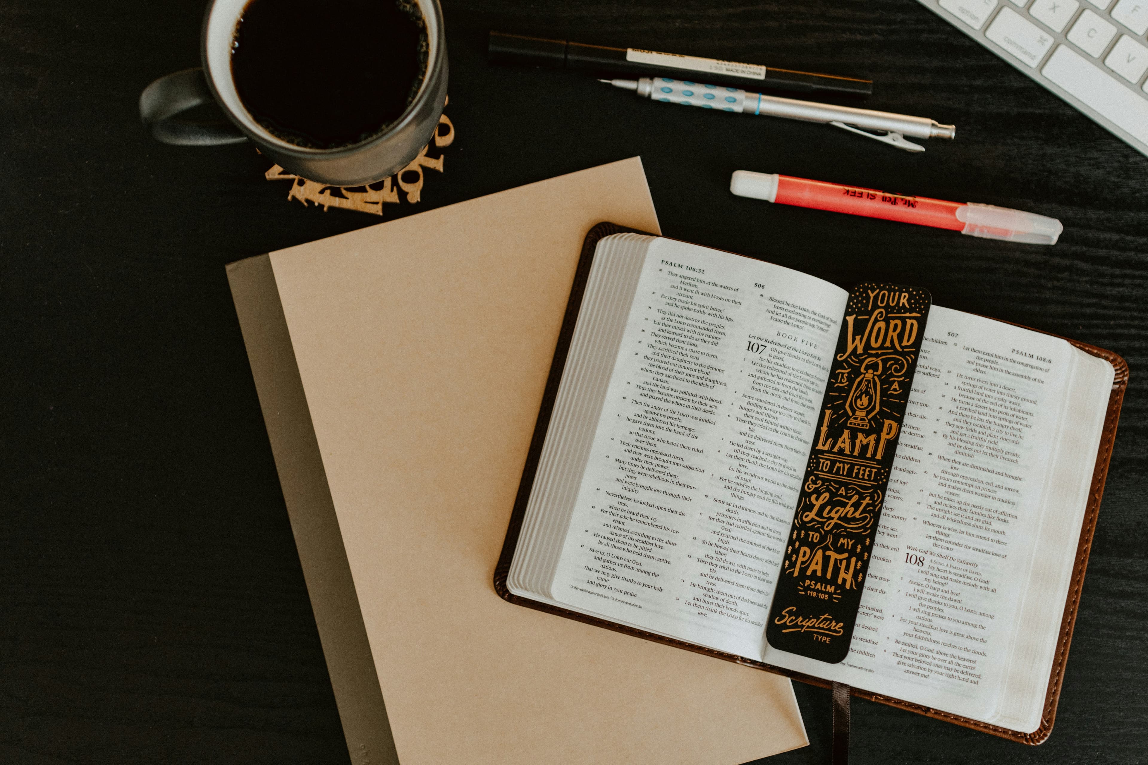 Bible, notebook, pens, highlighter and coffee sitting on a table for Bible study