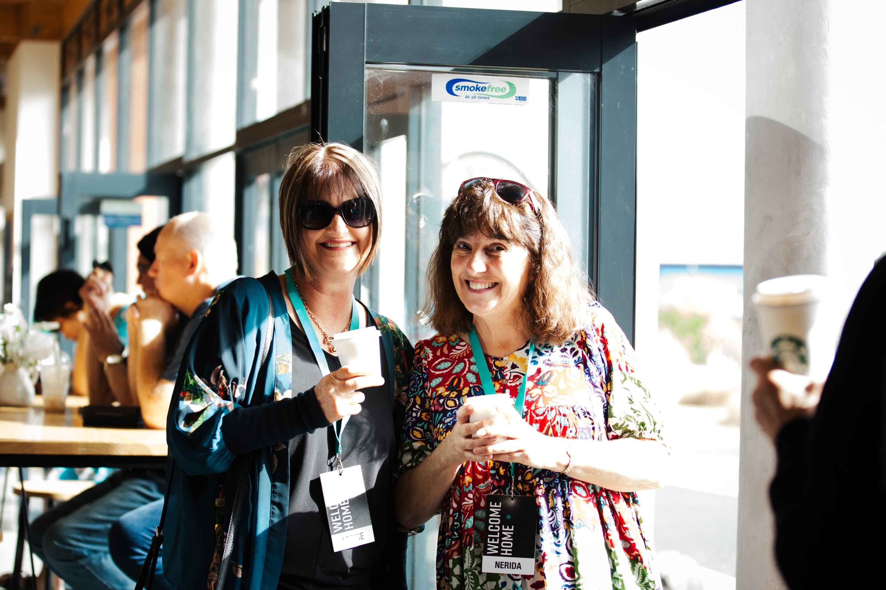 Two ladies smiling warmly in welcome