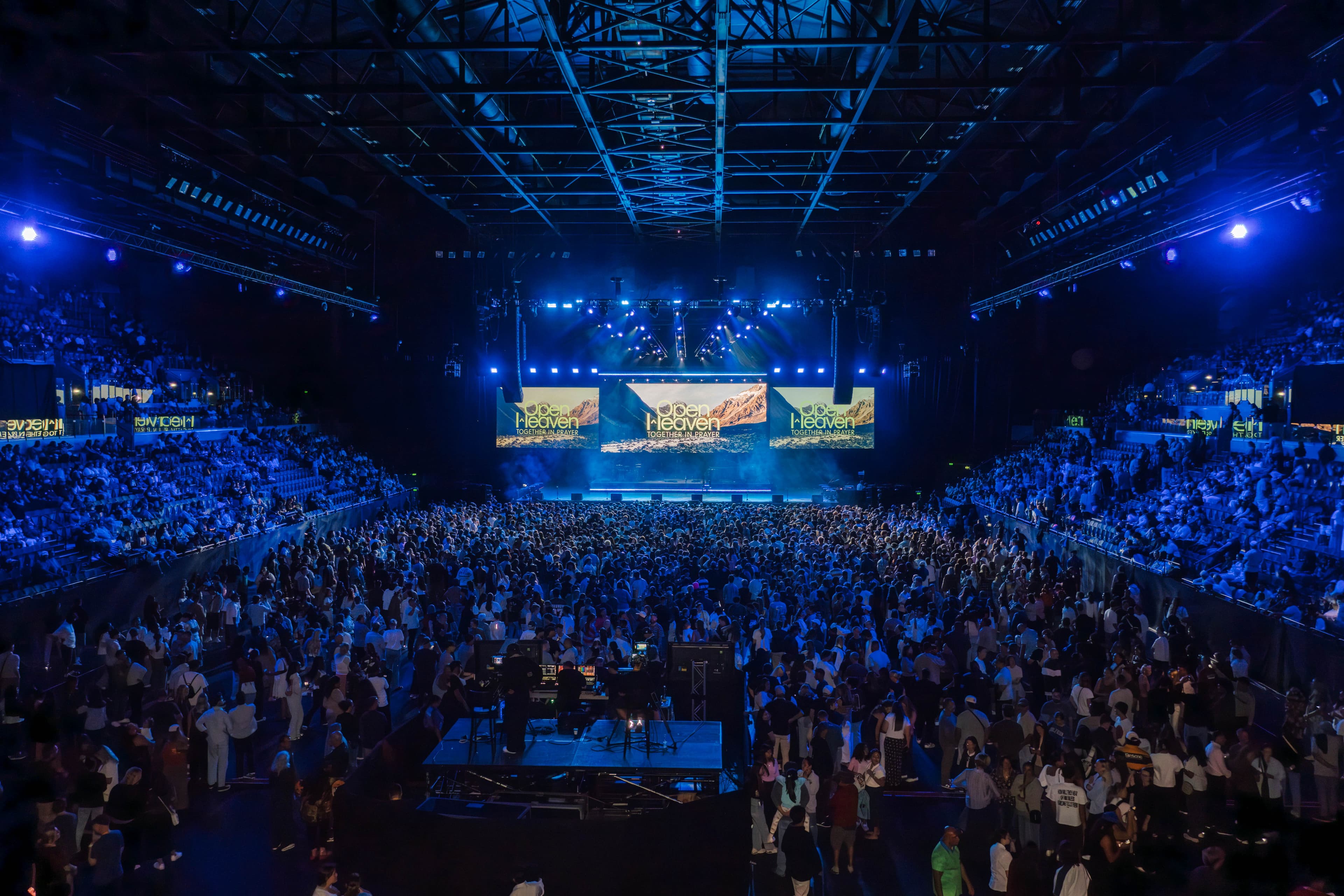 Wide shot of Open Heaven from the back of Spark Arena showing the entire crowd and screens above the stage